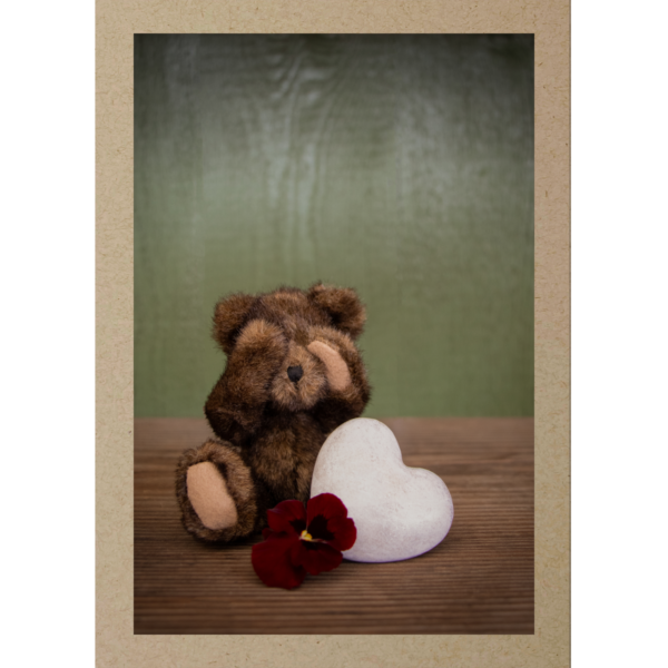 Trauriger Teddybär mit Herz und Blume